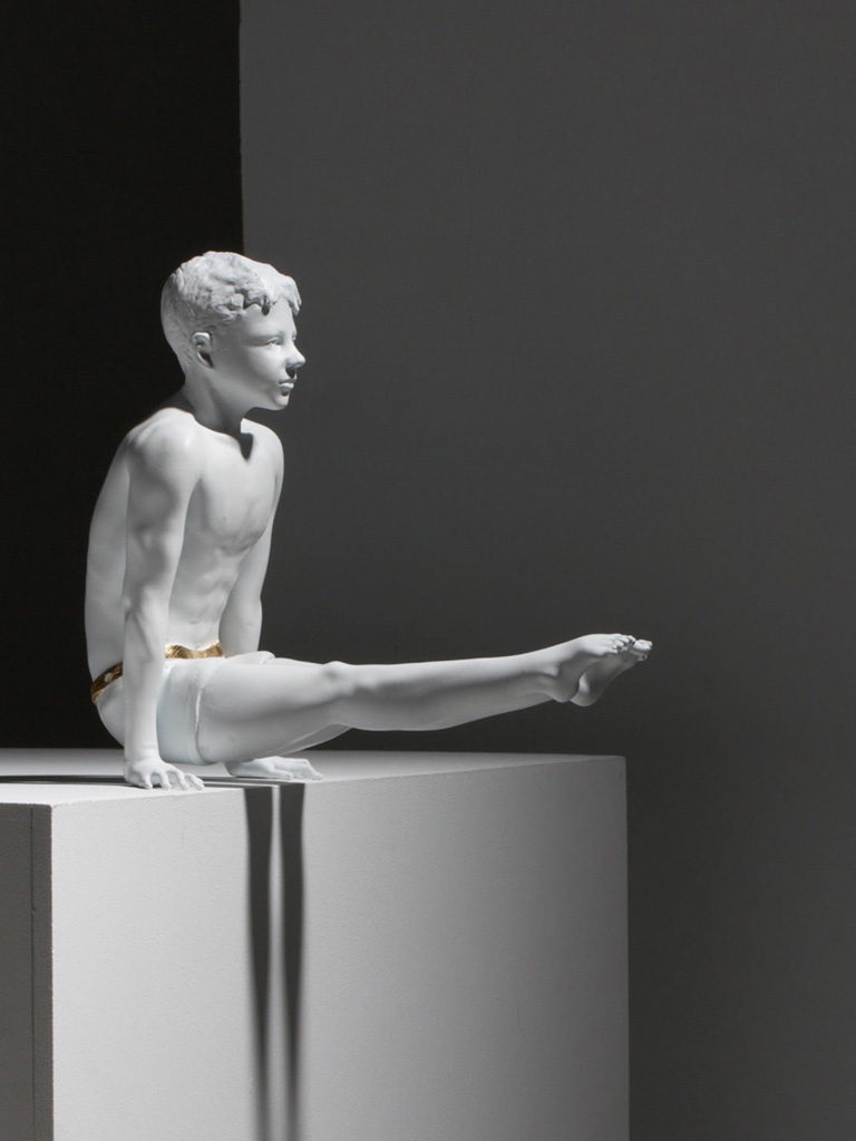 Scultura, bambino ginnasta che fa la squadra.